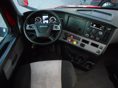 Truck cab dashboard and steering wheel interior of a Freightliner Cascadia 116 showing instrument cluster, center console, and control switches.