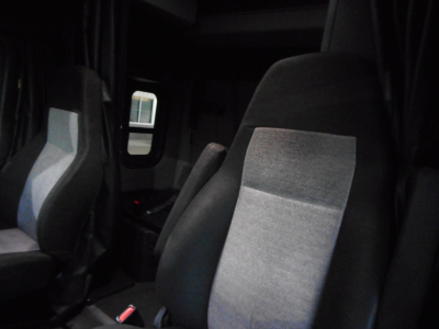 Freightliner Cascadia 116 interior seating view with grey and black upholstery, driver and passenger seats, cab area