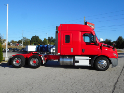 Freightliner Cascadia 116 tractor in red cab with sleeper, side view showing chassis and dual rear axles.
