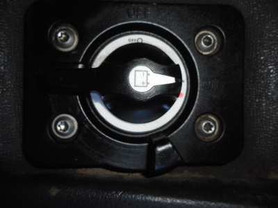 Truck fuel cap/lock with ignition switch surrounding ring, circular hatch in black dashboard area.