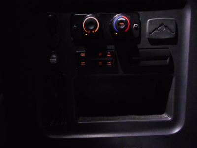 Freightliner Cascadia interior dash area showing climate control knobs and small electronic panel.