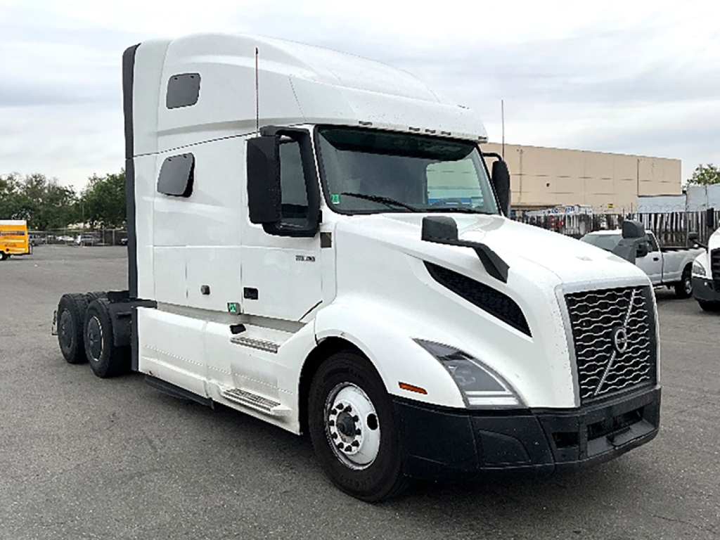 Volvo VNL 760 truck side view showing cab with sleeper, front grille, and three rear axles; notations visible on door and chassis area.