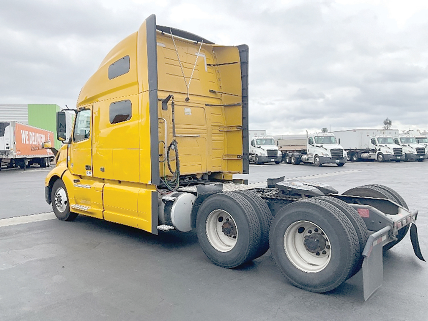 Volvo VNL 760 tractor cab in yellow side view showing sleeper cab and rear wheels.