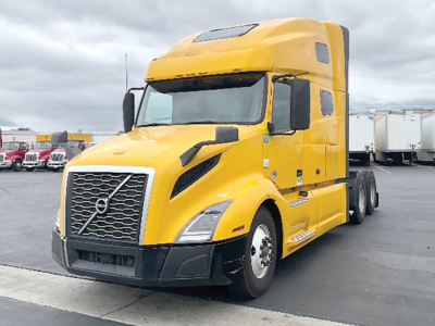 Volvo VNL 760 highway tractor in yellow, side and front view showing cab with sleeper, grille, headlights, and wheel rims.