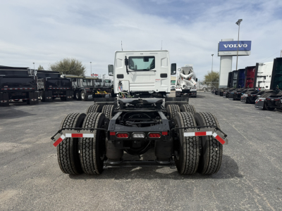 Truck chassis rear view showing dual rear axles, fifth wheel mount, and dual rear tires.