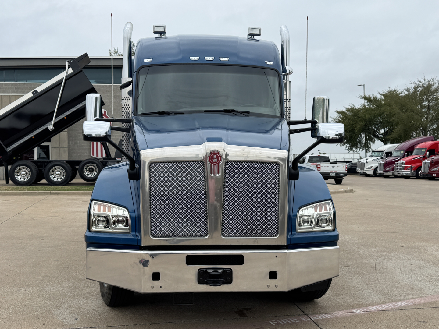 Front view of a blue 2019 Kenworth T880 truck with chrome grille, large bumper, and dual mirrors. No text visible on the image aside from vehicle styling.