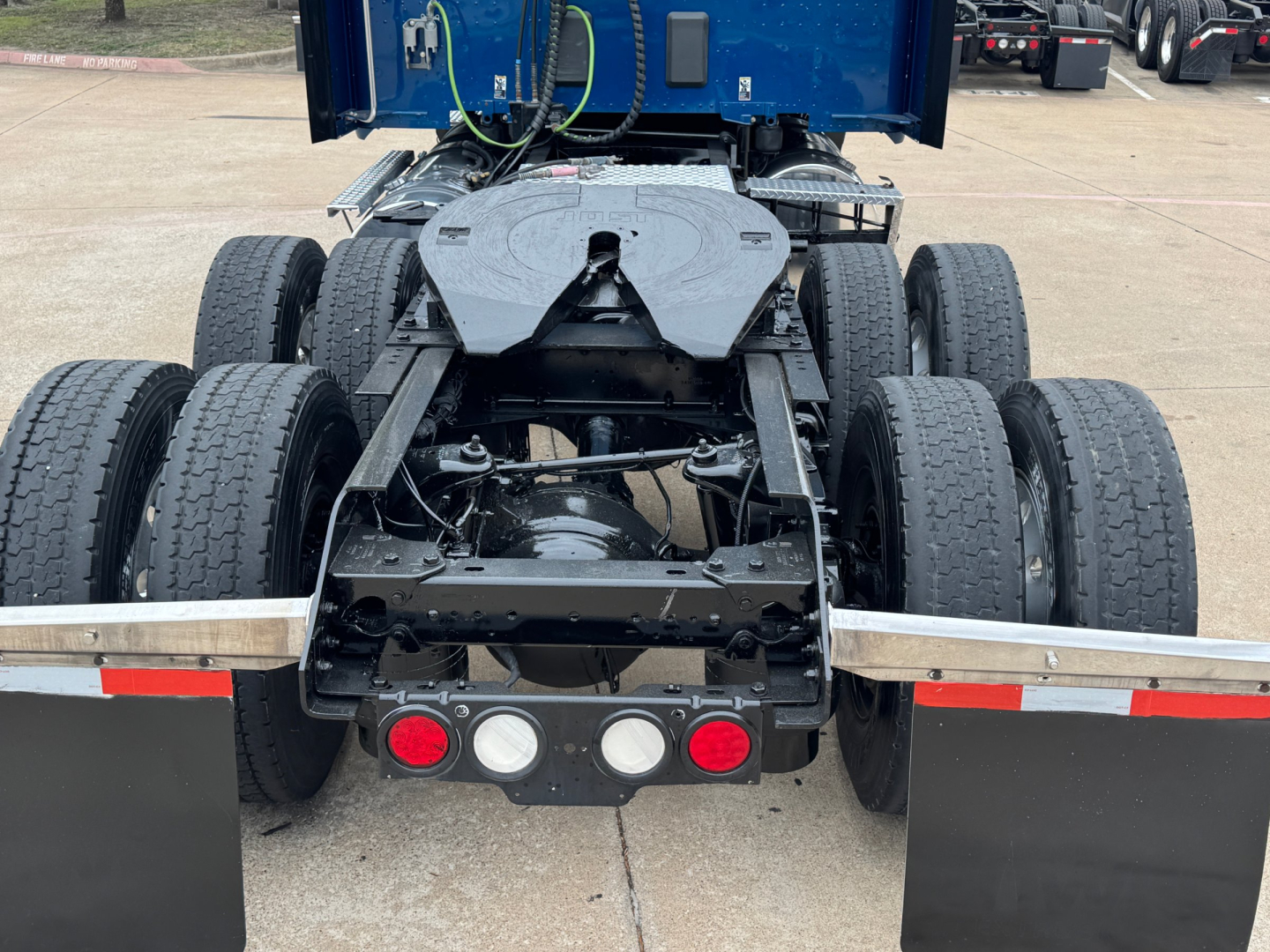 Kenworth T880 rear chassis showing tandem drive axles and heavy-duty frame with fifth wheel and rear lights visible.