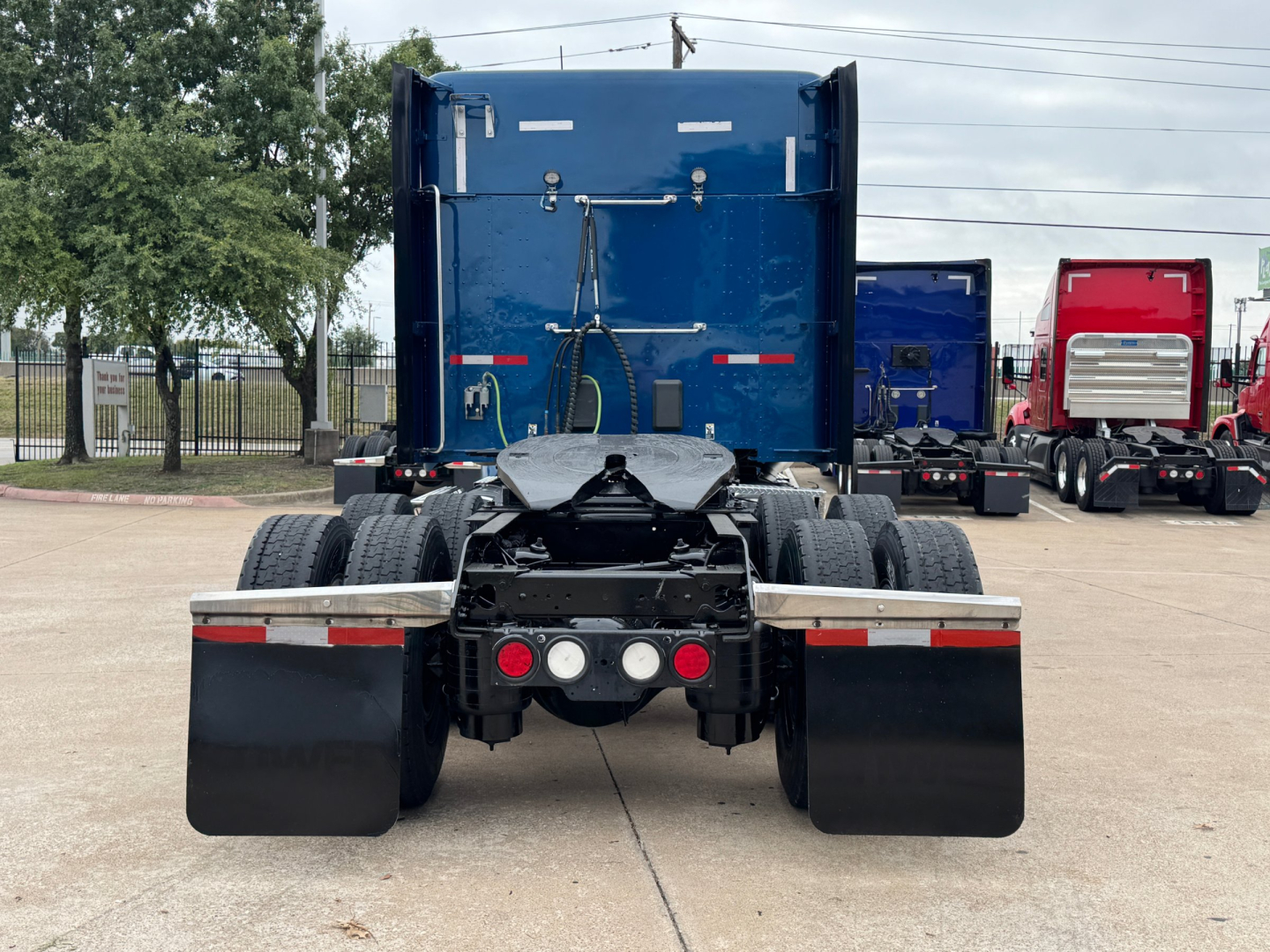Kenworth T880 rear view showing dual rear axles and mud flaps.