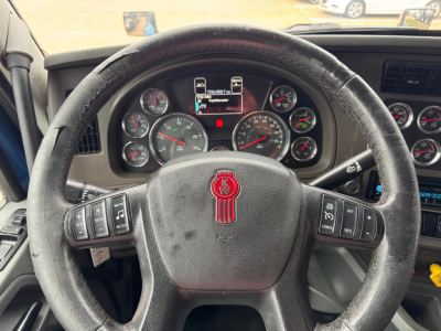 Kenworth T880 truck driver cockpit with steering wheel and gauges visible; center display shows several indicators, dashboard with multiple round gauges