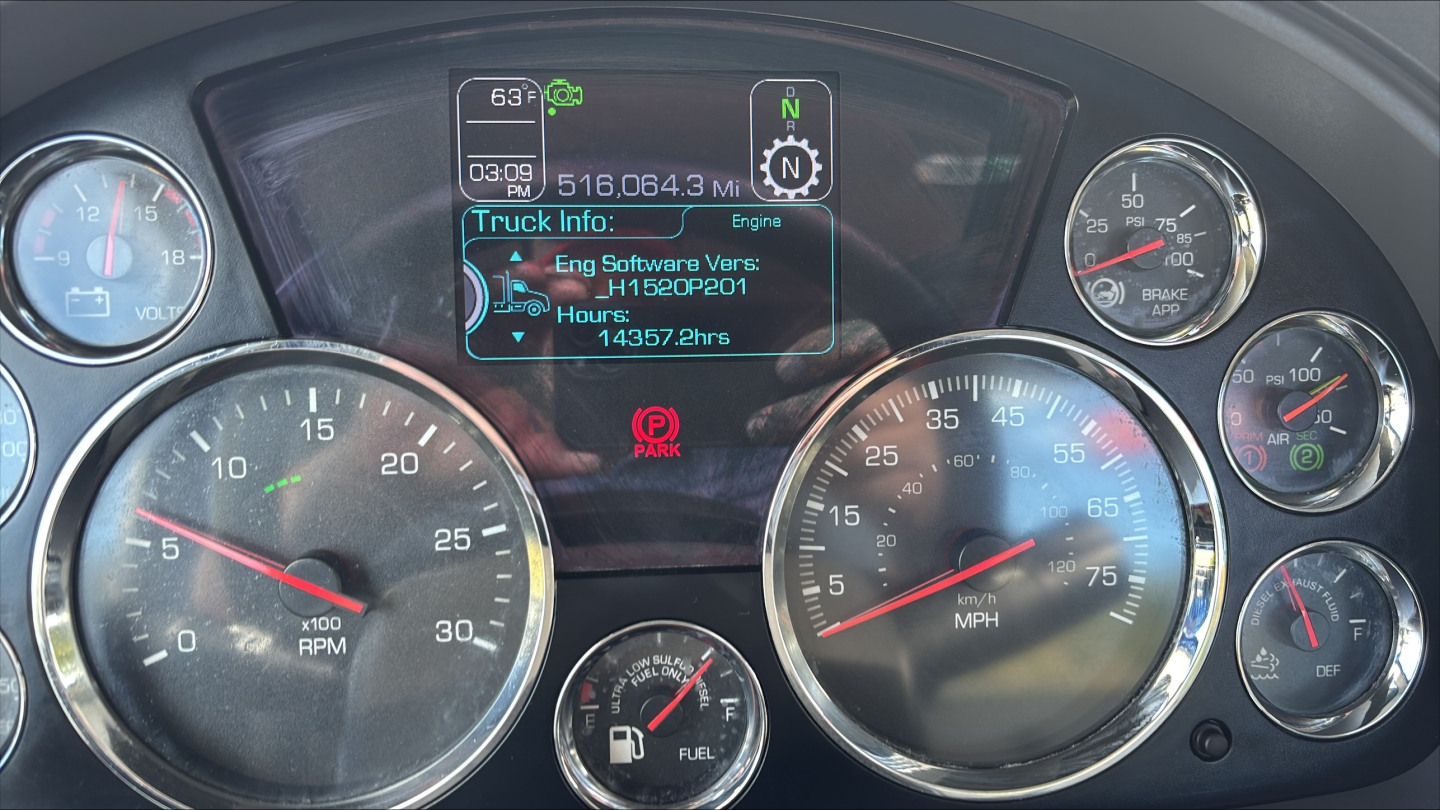 Kenworth T680 dash cluster showing gauges: tachometer, speedometer, fuel, temperature, and center screen with truck info including software version H1502P01 and hours 14357.2.