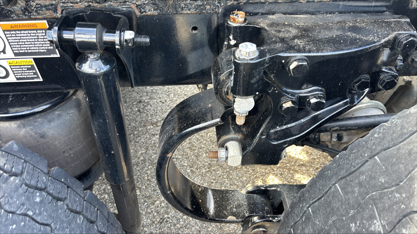 Kenworth T680 front suspension view showing steering linkages and chassis components in a used truck undercarriage.