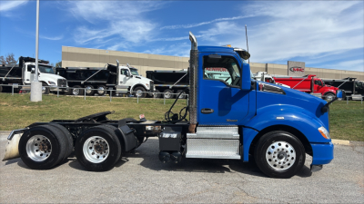 Kenworth T680 daycab tractor profile showing blue cab and chassis with dual rear axles and chrome fuel steps.