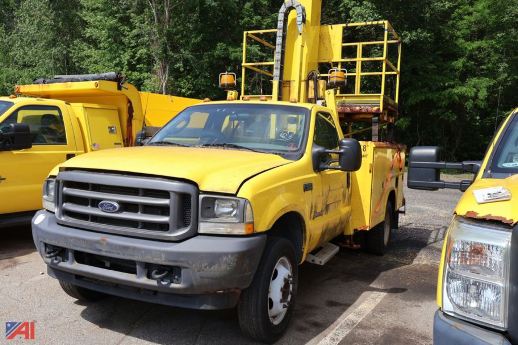Ford F-550 Super Duty utility lift truck in yellow, front view with mounted elevated service boom and rear work platform.