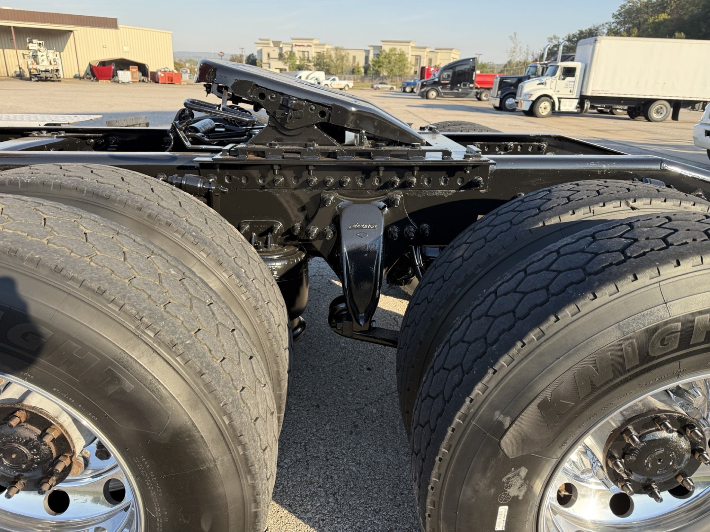 Freightliner Cascadia126 tractor chassis showing dual rear axles and fifth wheel prep with large tires and undercarriage components.