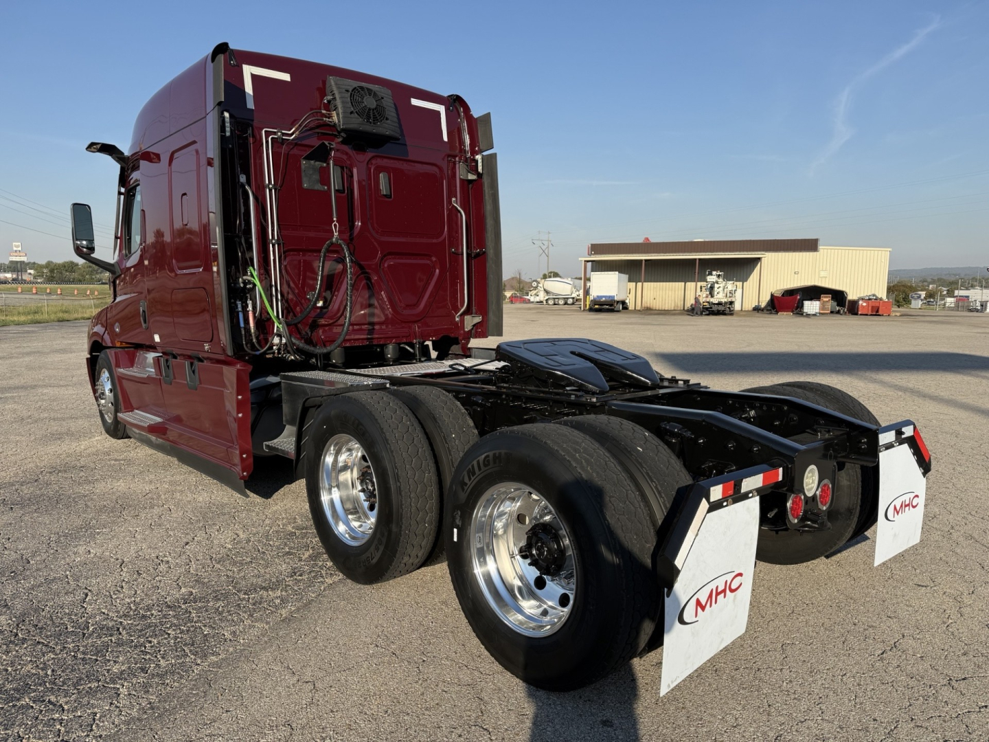 Freightliner Cascadia126 tractor side rear view showing dual rear axles and fifth wheel with MHC mudflaps