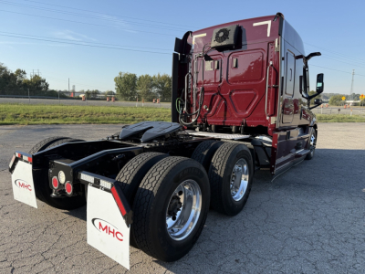 Rear angled view of a maroon Freightliner Cascadia 126 semi-truck tractor with dual rear axles and MHC mud flaps. Visible text on mud flaps: MHC