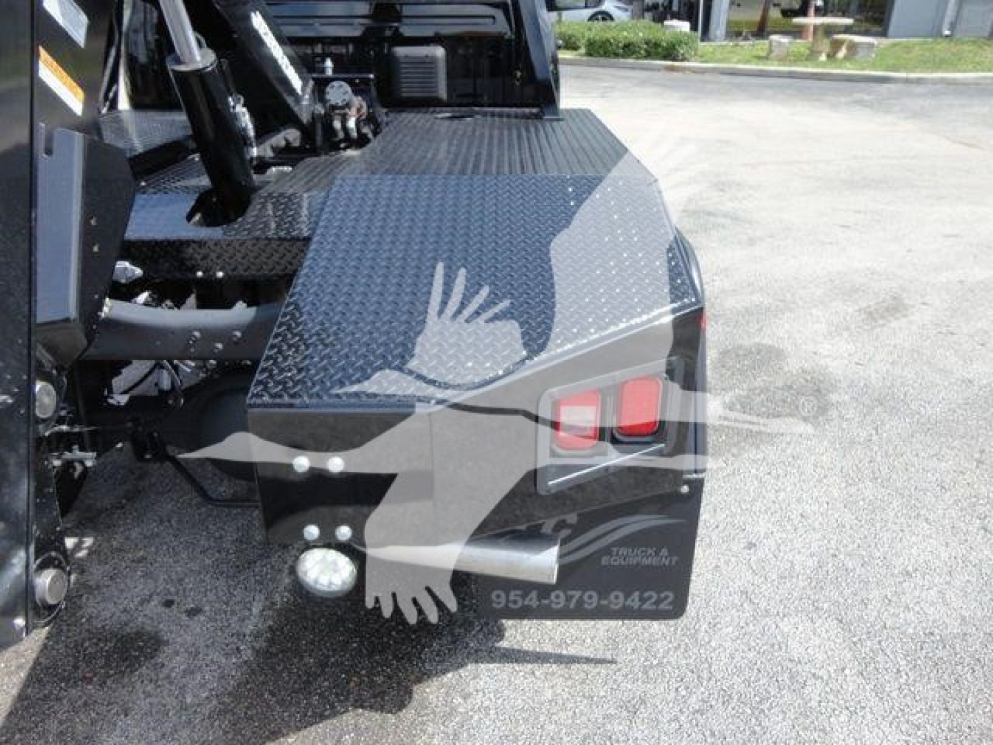 Truck bed area of a 2024 Ram 4500 SLT with diamond plate steel toolbox, winch equipment, and rear lights visible.