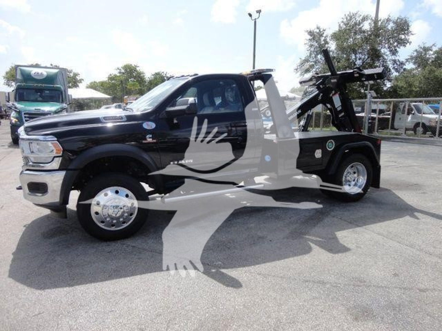Ram 4500 SLT truck with hydraulic tow/roll-back winch in black, side view showing heavy-duty winch equipment and flatbed.