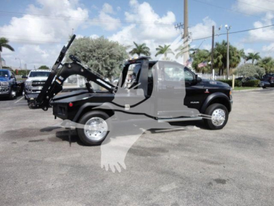 Ram 4500 SLT truck with a winch in a dealership lot; side view shows tow hook mechanism and folded bed winch apparatus.