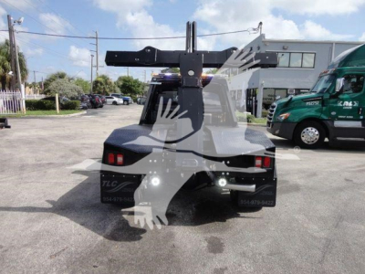 Back view of a 2024 Ram 4500 SLT truck with a mounted winch and heavy-duty hitch apparatus in the bed area.