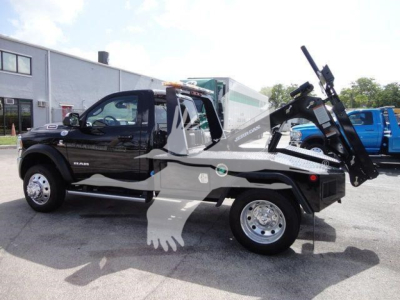 Tow truck side view showing Ram 4500 SLT with winch equipment and hydraulic tilt bed, black exterior, stock number J33421FM visible, new truck.
