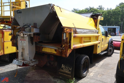 Dump truck bed of a 2015 Ford F450 Super Duty with yellow dump body and plow equipment visible from rear side view.