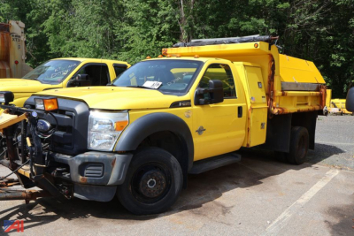 Ford F-450 Super Duty dump/sander/plow truck in serviceable condition with yellow body and utility bed.