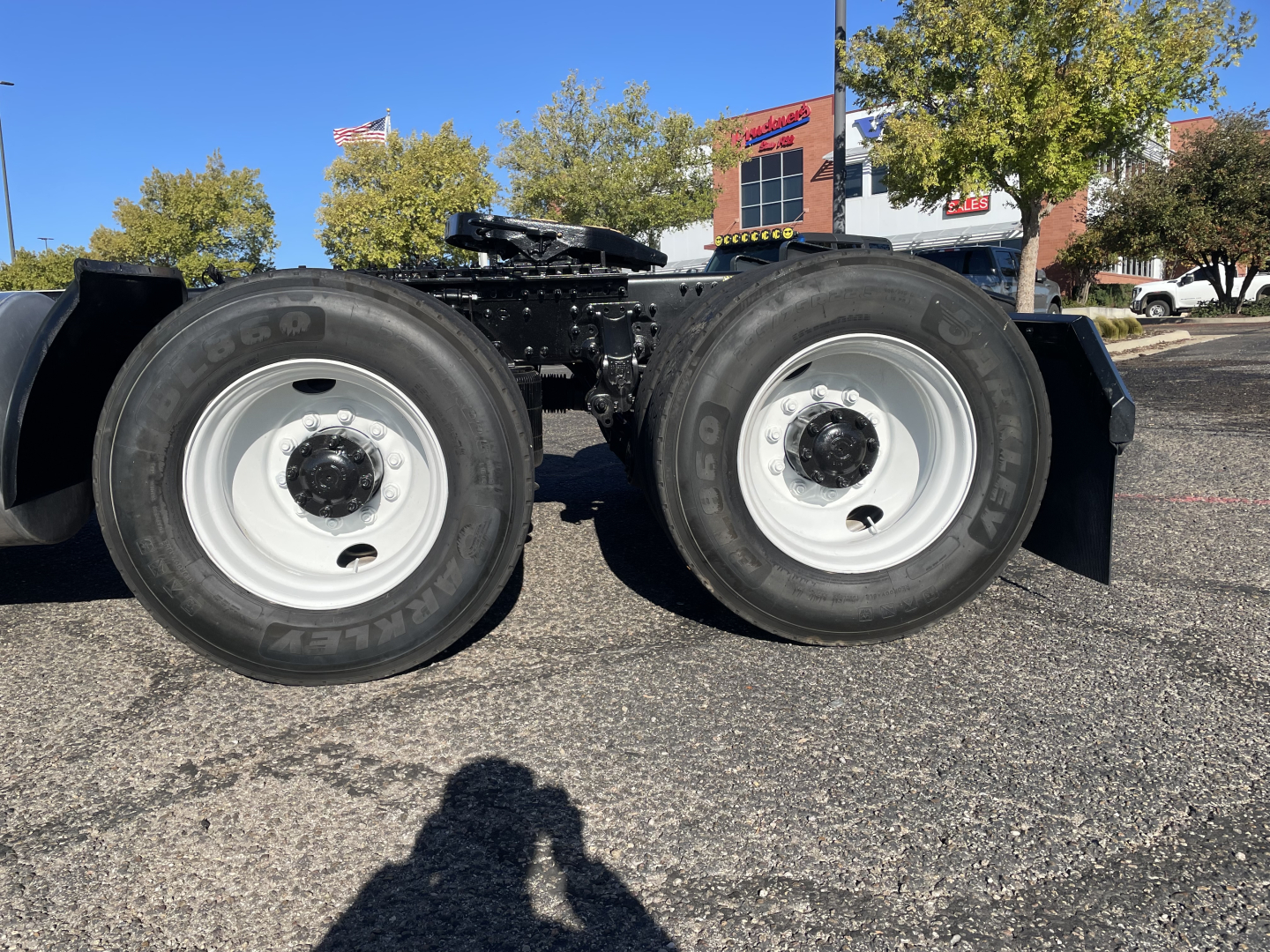 Dual rear axles of a Mack AN64T truck showing white wheels and Goodyear tires.