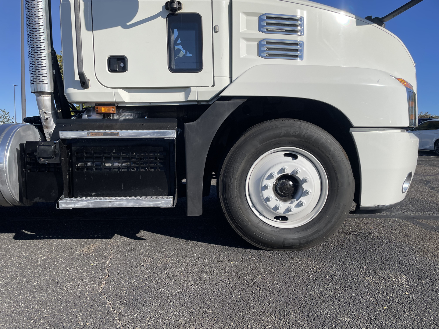 Mack AN64T conventional daycab front-left wheel light gray exterior with steps and fuel tank visible