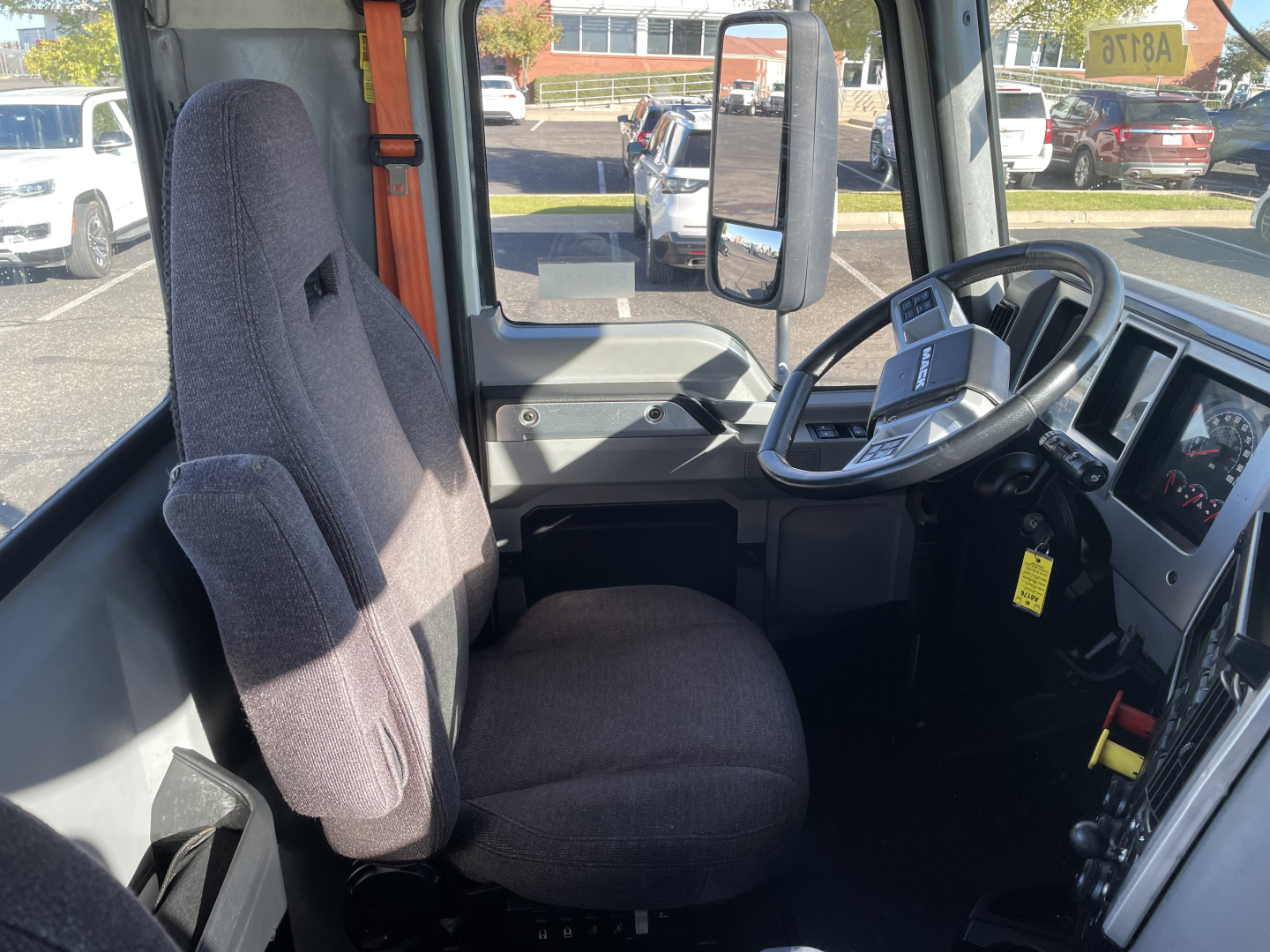 Cab interior of 2020 Mack AN64T daycab showing driver seat and steering wheel with dashboard and side window.