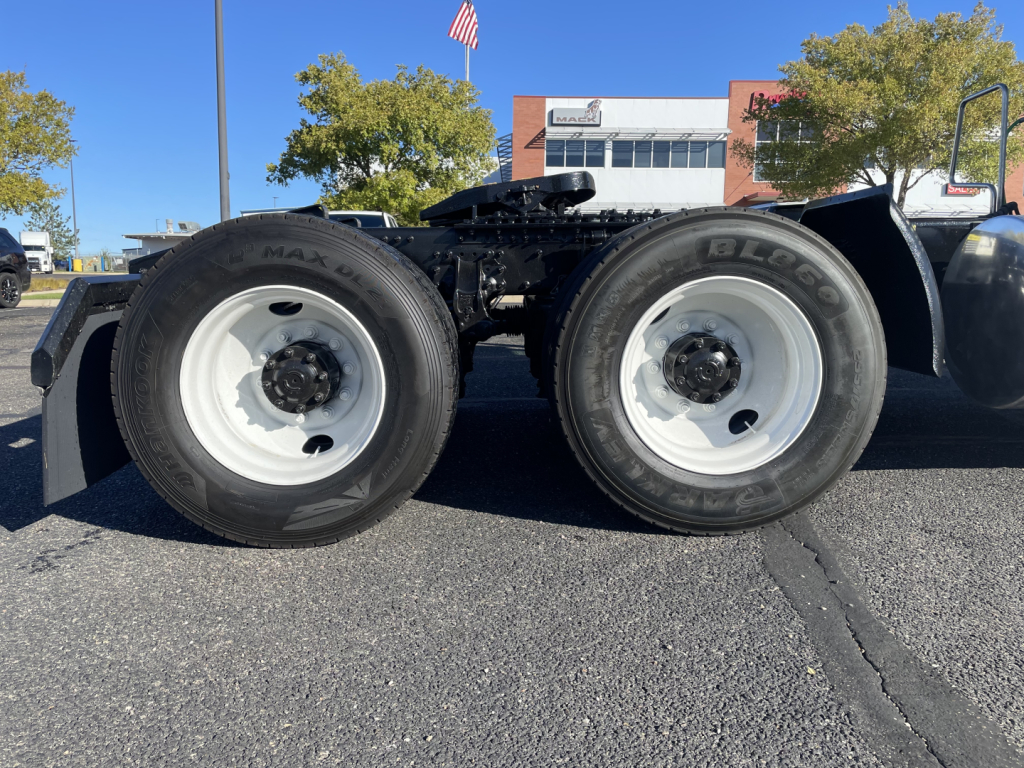 Mack AN64T tractor dual rear wheels view showing white rims and dual tires, chassis frame, undercarriage and part of cab; no visible text readable on components.