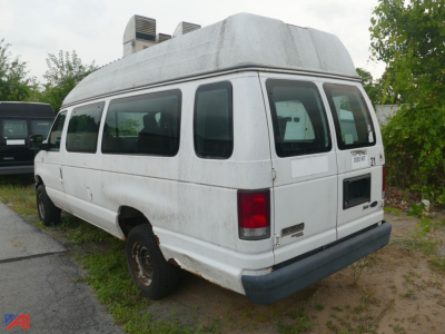 Ford E-350 Super Duty cargo van with wheelchair lift, rear side view showing lift compartment and back doors.