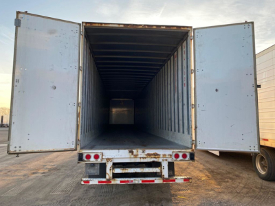 Trailer cargo area of a 2013 Stoughton Van with rear doors open, showing empty interior and metal ribbed walls.