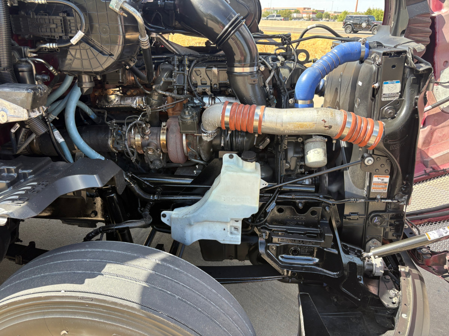 Kenworth T680 engine bay showing intake piping, hoses, and components in view.
