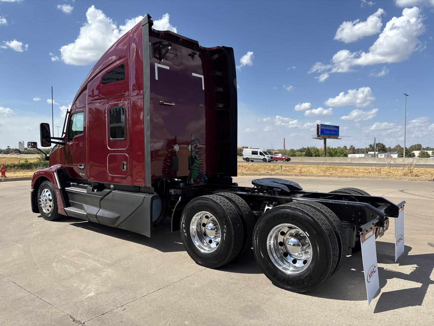 Kenworth T680 tractor in maroon, side view with sleeper cab, dual rear axles, chrome wheels, no trailer attached.