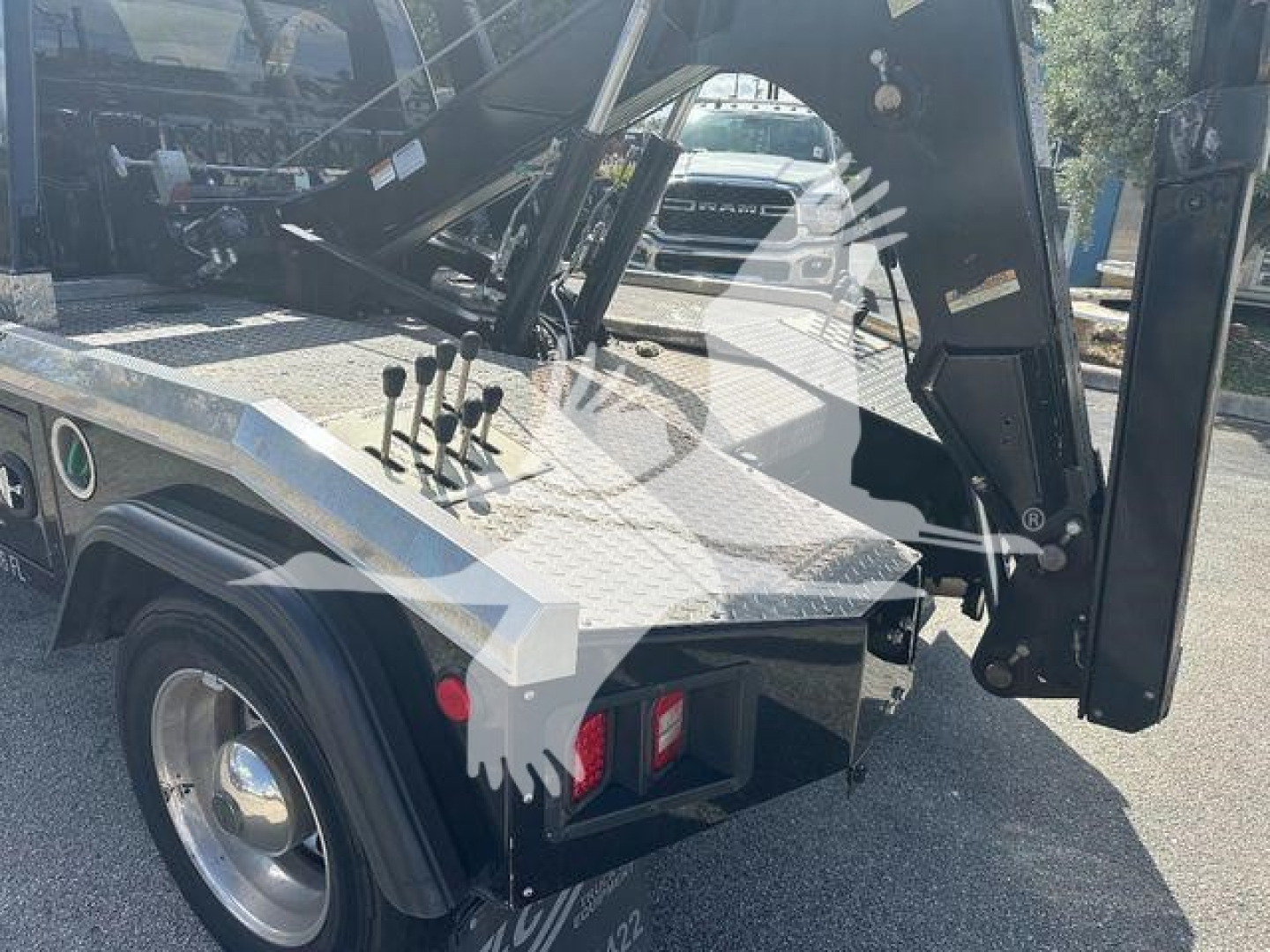 Truck body with winch mechanism and control levers visible on a diamond plate bed.
