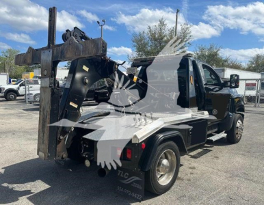 Truck with winch and heavy tow setup showing rear and side view, black frame, metal deck, and hydraulic components.