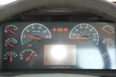 Dashboard of a Volvo truck showing multiple gauges and warning lights; center area has a blurred rectangular display; various dials for RPM, speed, fuel, temperature, and air pressure.