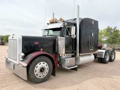 Peterbilt 379 UltraCab extended hood truck in profile view showing large chrome exhaust stacks and black cab with maroon fenders.