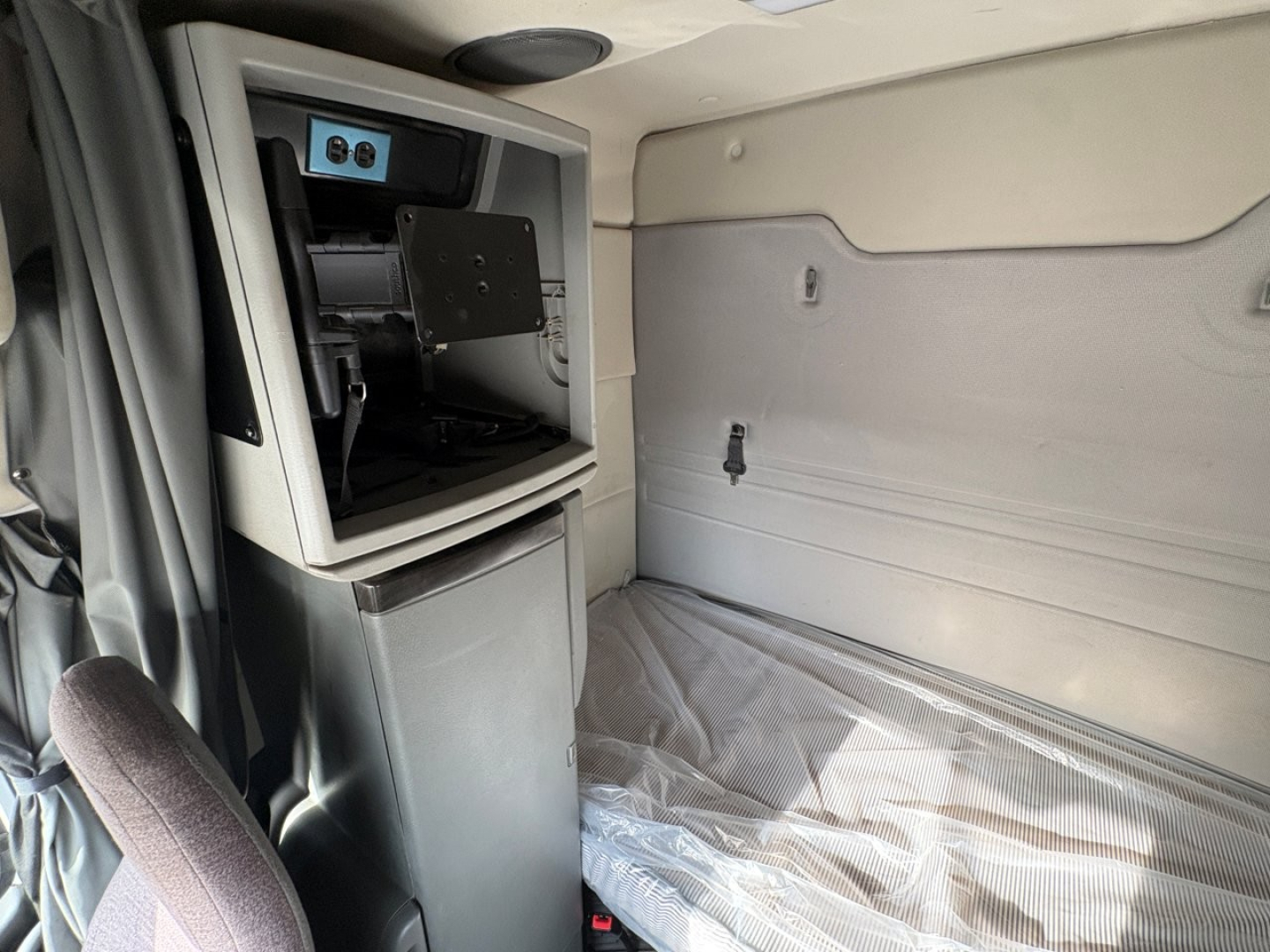 Volvo VNR64T64 sleeper cab dashboard and bulkhead area with storage compartment visible.