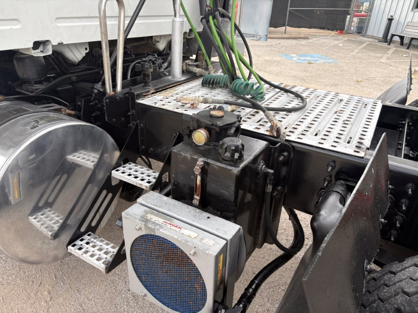 Volvo VNR truck chassis and step area showing air filter housing and wiring harnesses around the frame.