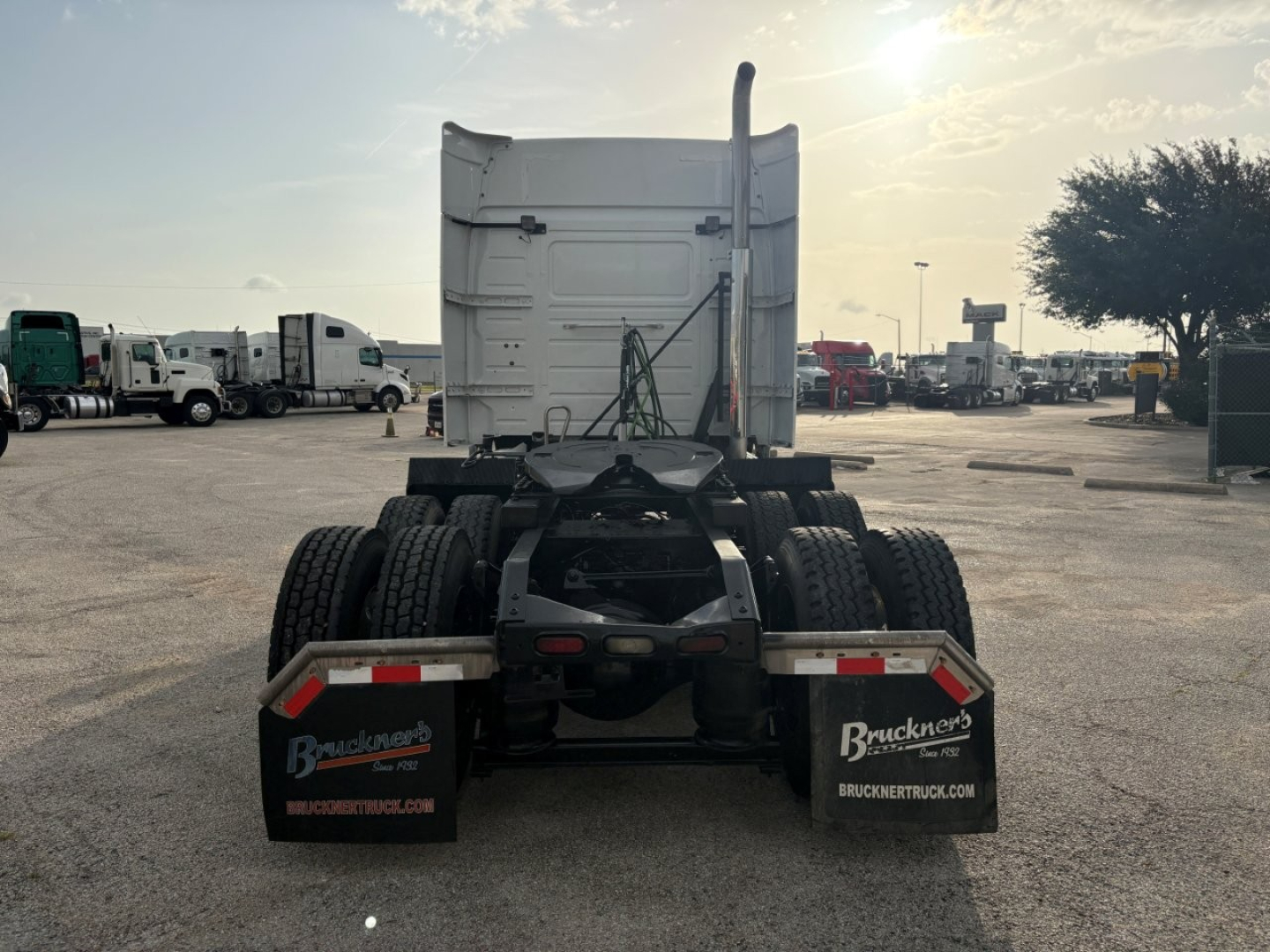 Rear view of a Volvo VNR truck tractor chassis with fifth wheel removed; dual rear axles, mud flaps showing Buckner's Truck logos
