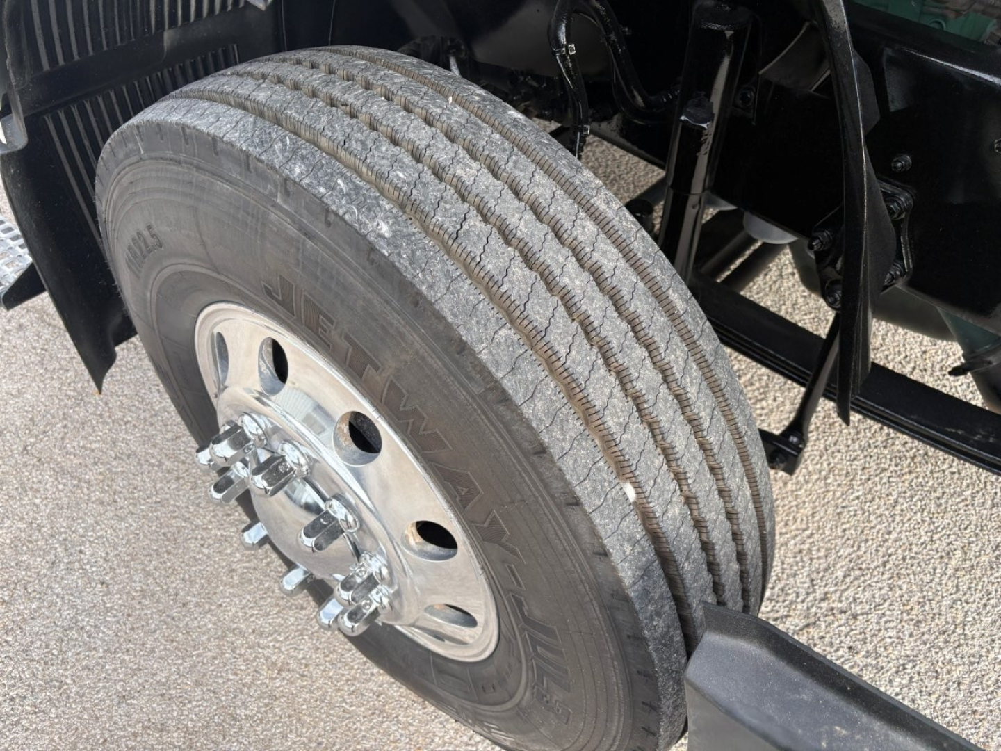 Dual rear axle wheel with tire tread and hub, Volvo VNR truck chassis visible in background.