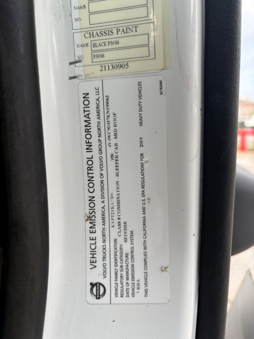 Vehicle information label and chassis paint tag on Volvo VNR truck door jamb showing VIN 4V4WC9DH7KN199063 and disclosure labels.