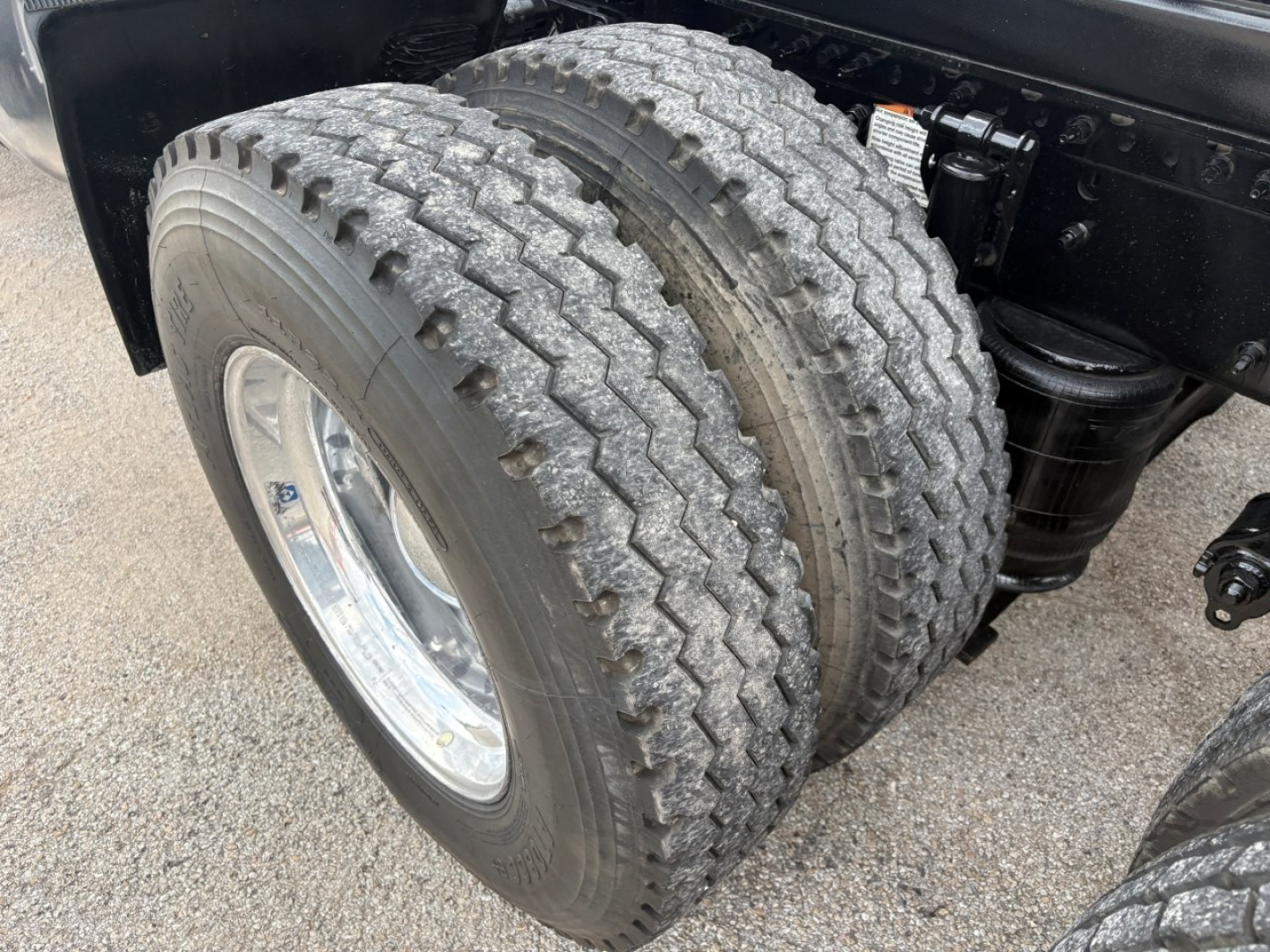 Dual rear truck tires showing tread on a Volvo VNR64T640 chassis with suspension components.