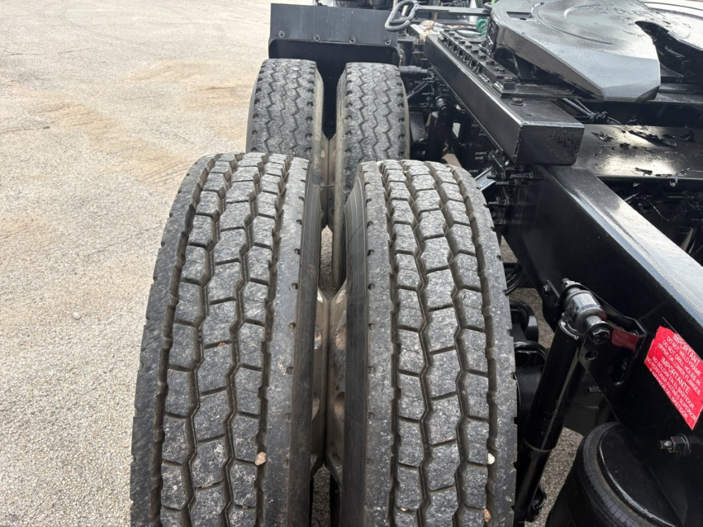 Dual rear tractor tires and chassis of a 2019 Volvo VNR64T640 on a used truck chassis. Visible components include tire treads, wheel rims, and part of the frame and hydraulic lines.