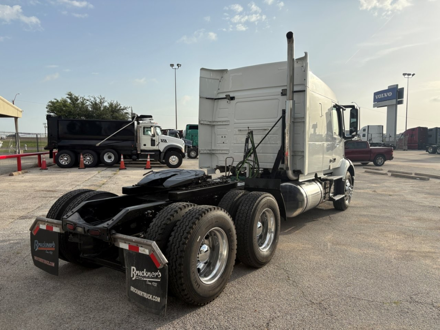 Volvo VNR64T640 sleeper tractor rear/side view showing triple rear axle, fifth wheel, and mud flaps.