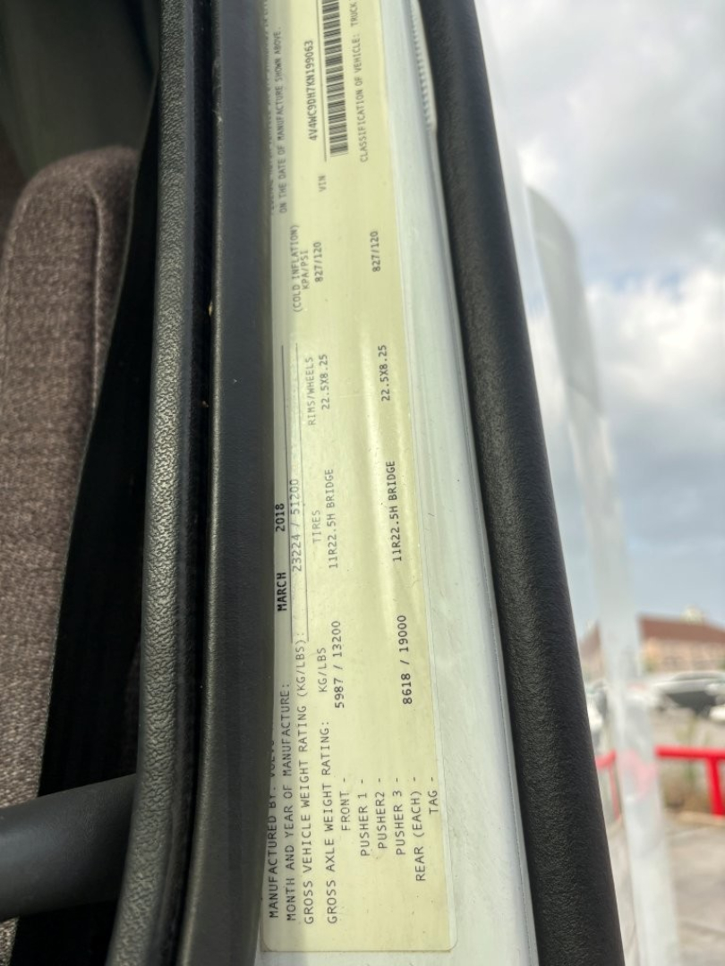 Vehicle identification plate visible in door jamb with VIN and vehicle specs, showing numbers and barcodes.