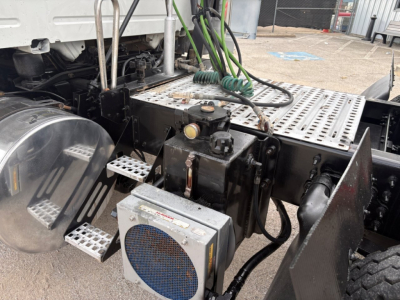 Volvo VNR truck chassis and step area showing air filter housing and wiring harnesses around the frame.