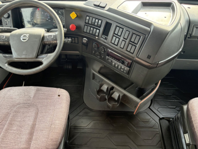 Dashboard and steering wheel area of a 2019 Volvo VNR sleeper cab showing steering wheel, control panel, and cup holders.